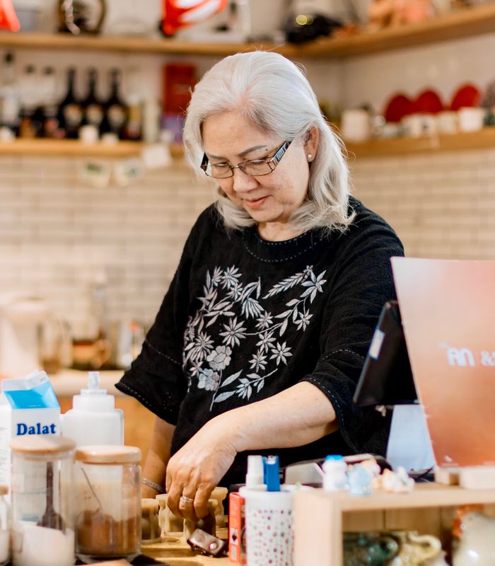 Une commerçante dans sa boutique, concentrée sur son travail.